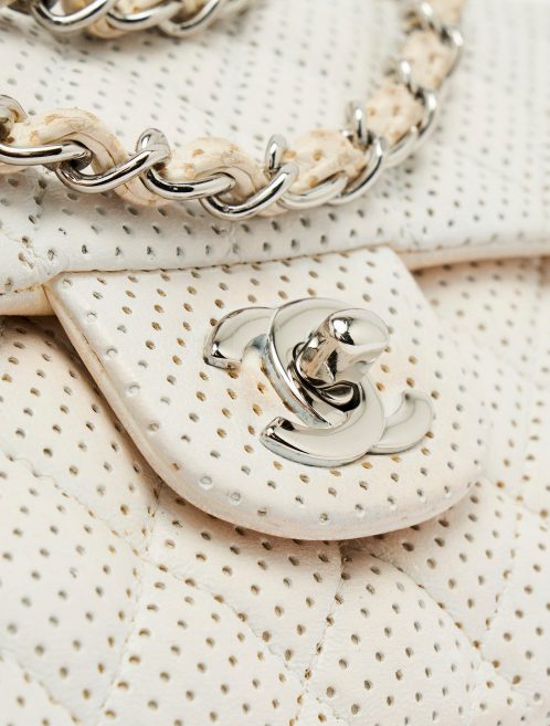 Silver turn-lock detail of a pre-loved Chanel Timeless Baguette Lamb Off White on SACLÀB