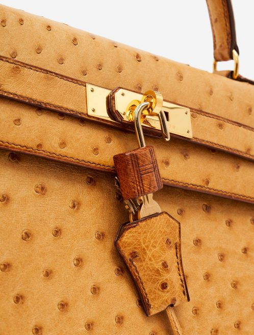 Hardware detail of a pre-loved Hermès Kelly 32 Ostrich Gold on SACLÀB