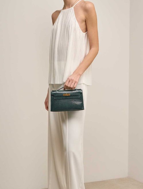 Hermès Kelly Pochette Niloticus Lizard Vert Cyprès on Model | Sell your designer bag