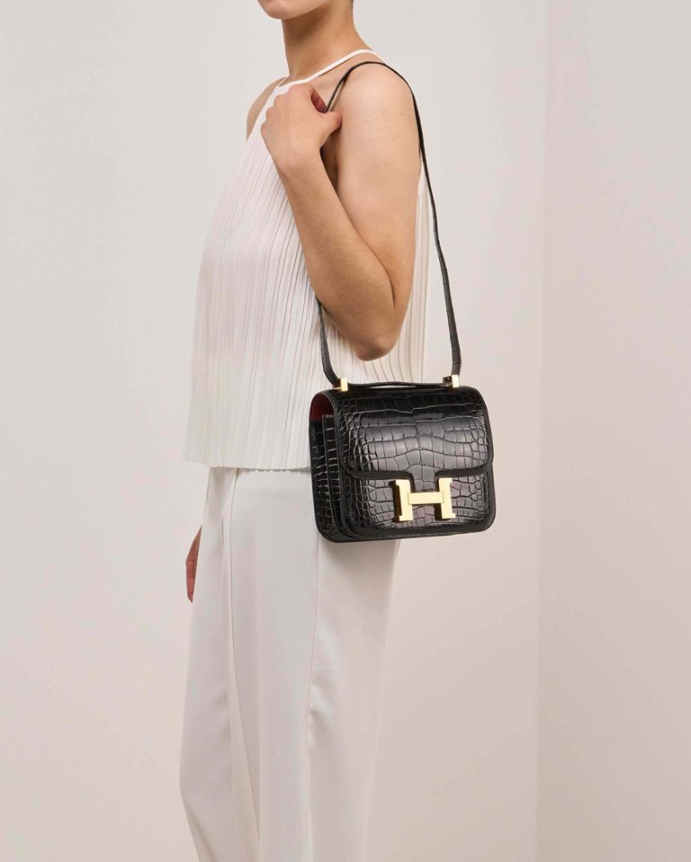 Hermès Constance 24 Alligator Mississippi Black / Rouge Grenat on Model | Sell your designer bag