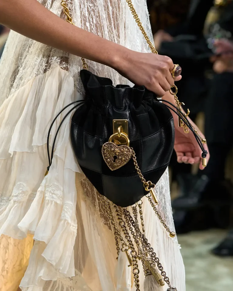 A Chloé drawstring bag in black leather, detailed with cascading gold chains.