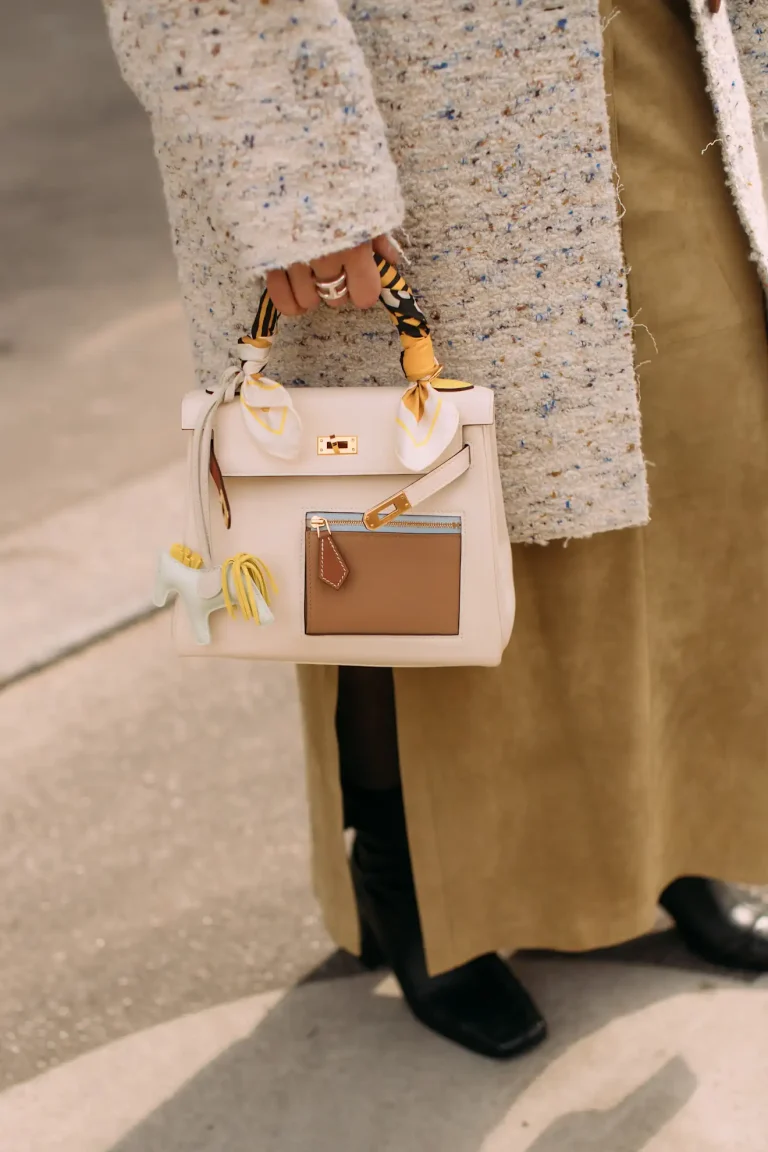 Cream Hermès Kelly with colorful scarf on handles and charm